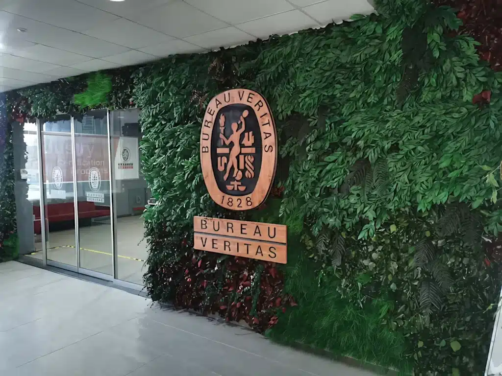 Bureau Veritas girişinde kurumsal amblemli yeşil duvar uygulaması