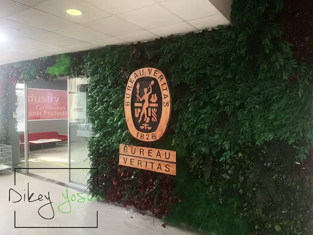 Bureau Veritas amblemi ve bitki dokulu kurumsal duvarın detay görünümü