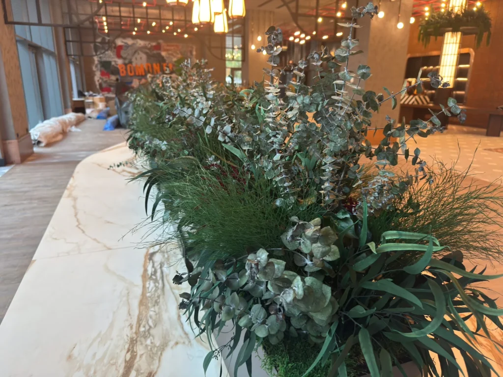 Canopy by Hilton İzmir'de kıvrımlı masa üzerinde bitki düzenlemesi
