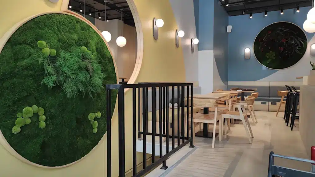 Fit House iç mekânında dairesel çerçeveli yosun duvar kompozisyonu