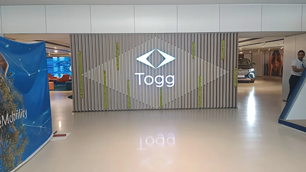 Togg Ankara alanında aydınlatmalı logo ve yeşil şeritli duvar tasarımı